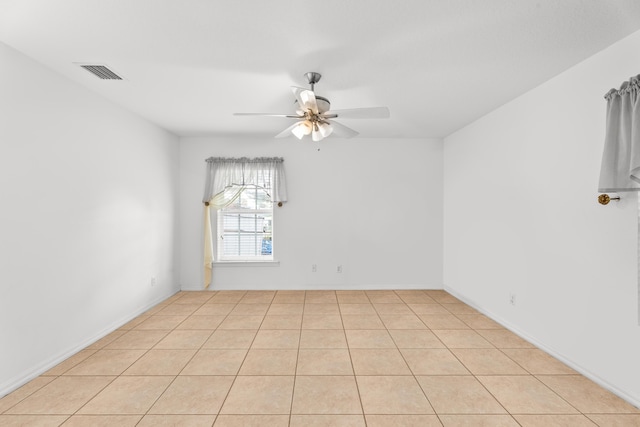 spare room with ceiling fan and light tile patterned floors