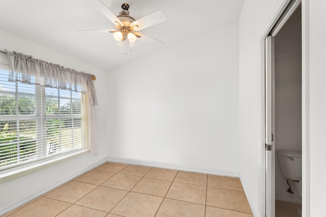 tiled spare room featuring ceiling fan