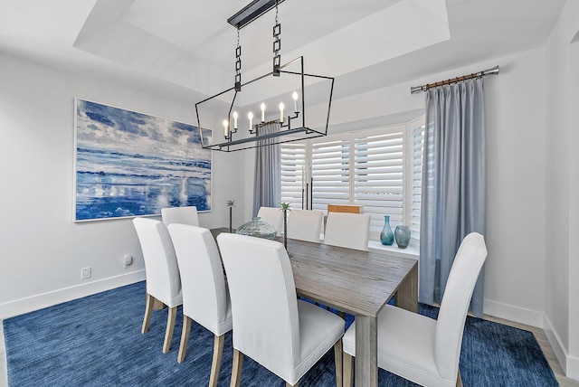 dining room with a tray ceiling and a chandelier