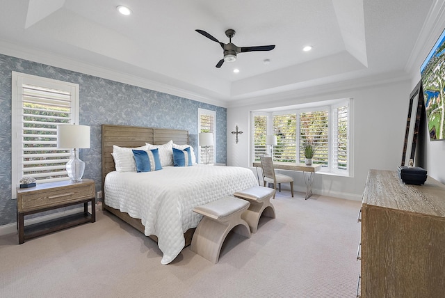 bedroom with ceiling fan, a tray ceiling, crown molding, and light carpet