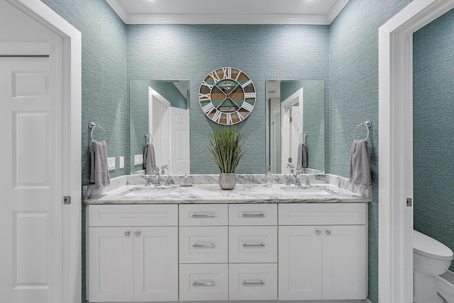 bathroom featuring toilet, vanity, and ornamental molding