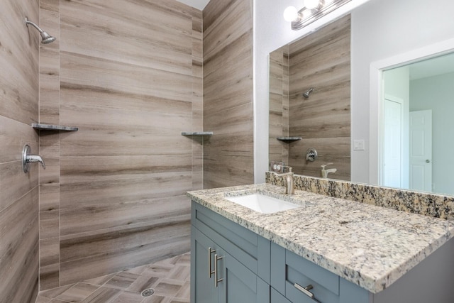 bathroom with vanity and tiled shower