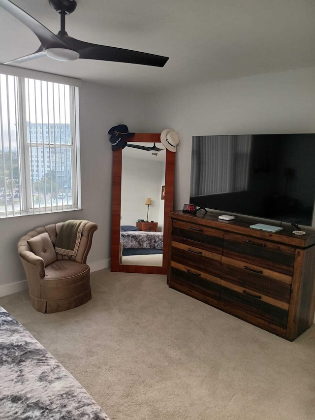 interior space with a ceiling fan, carpet, and baseboards