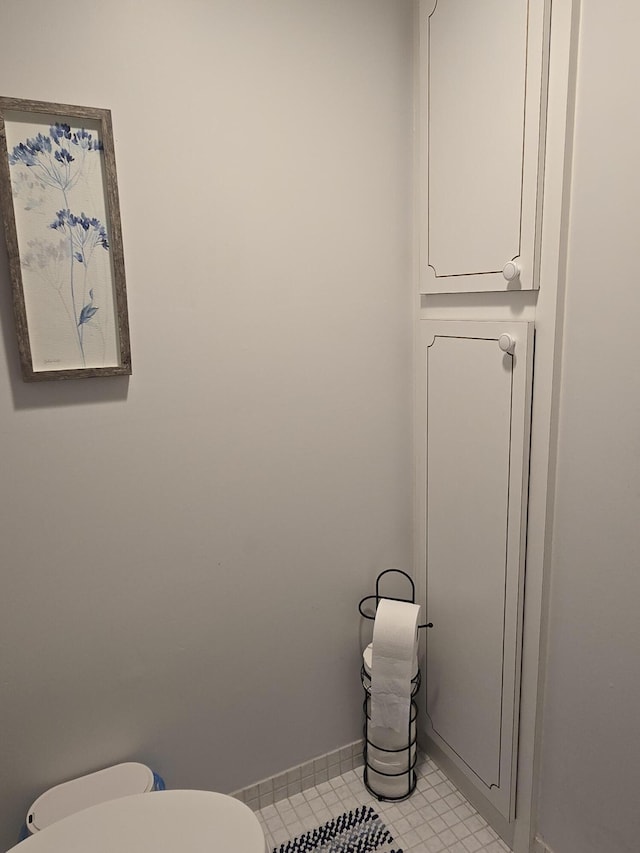 bathroom with toilet and baseboards