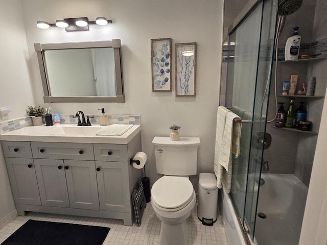 full bathroom with tile patterned flooring, combined bath / shower with glass door, toilet, and vanity