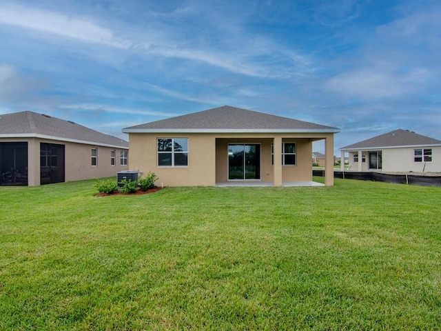 back of house with central AC unit, a lawn, and a patio