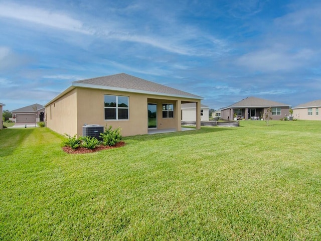 rear view of property featuring central air condition unit and a lawn