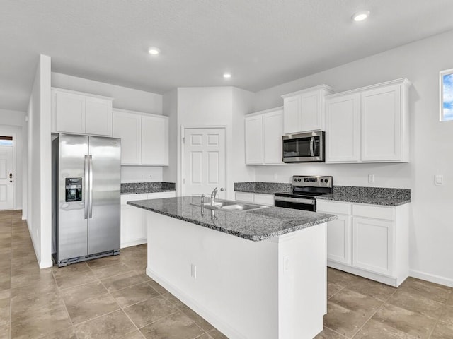 kitchen with white cabinetry, sink, stainless steel appliances, and a center island with sink