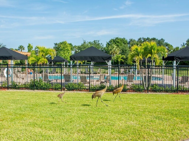 view of jungle gym with a yard and a community pool