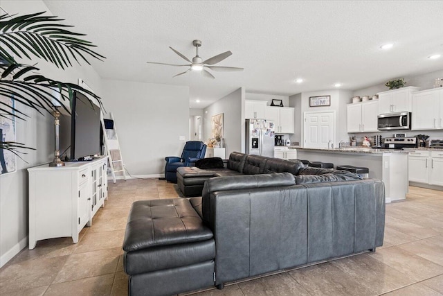 living room with ceiling fan and a textured ceiling