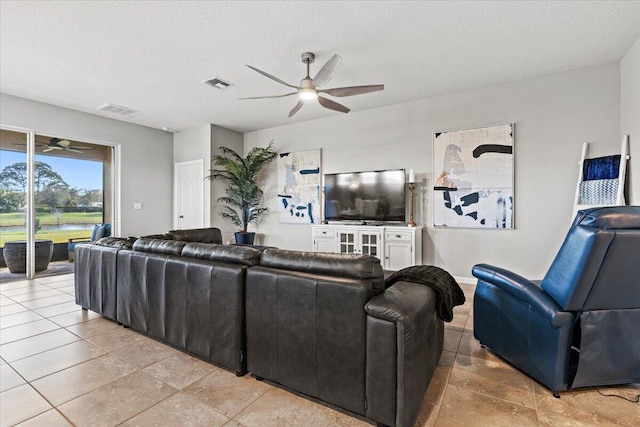 tiled living room with ceiling fan and a textured ceiling