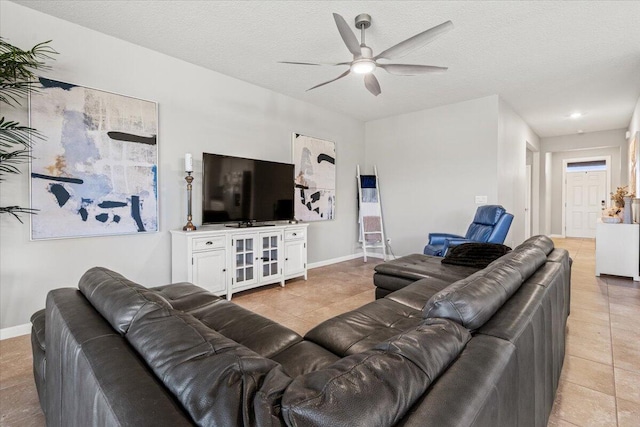 living room featuring light tile patterned floors, a textured ceiling, and ceiling fan