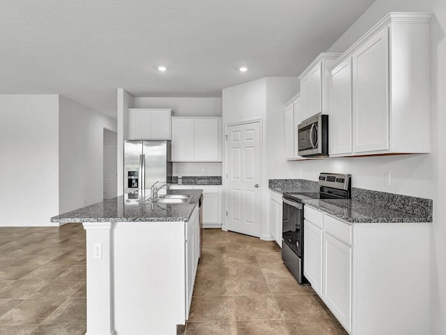 kitchen with stainless steel appliances, sink, a center island with sink, and white cabinets