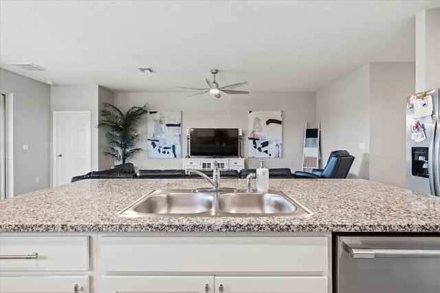 kitchen featuring sink, white cabinets, and a center island with sink