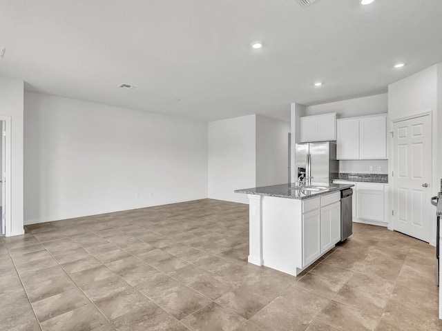 kitchen with white cabinetry, stainless steel refrigerator with ice dispenser, dark stone countertops, and a center island with sink