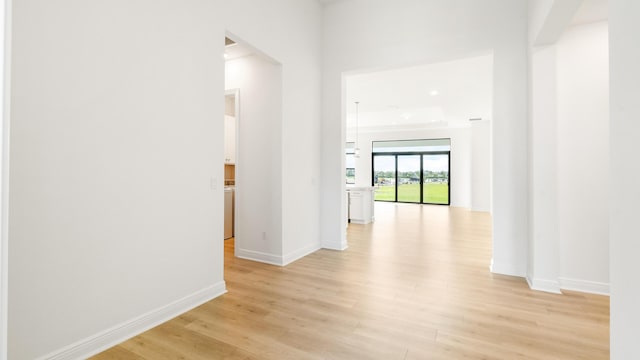 hallway with light hardwood / wood-style floors