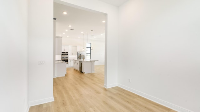 hallway with sink and light hardwood / wood-style flooring