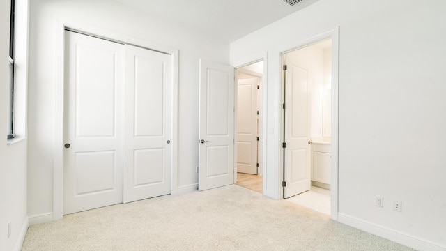 unfurnished bedroom featuring light colored carpet and a closet