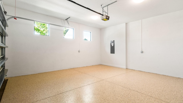 garage with electric panel and a garage door opener