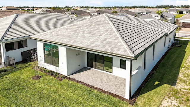 rear view of property featuring cooling unit and a yard