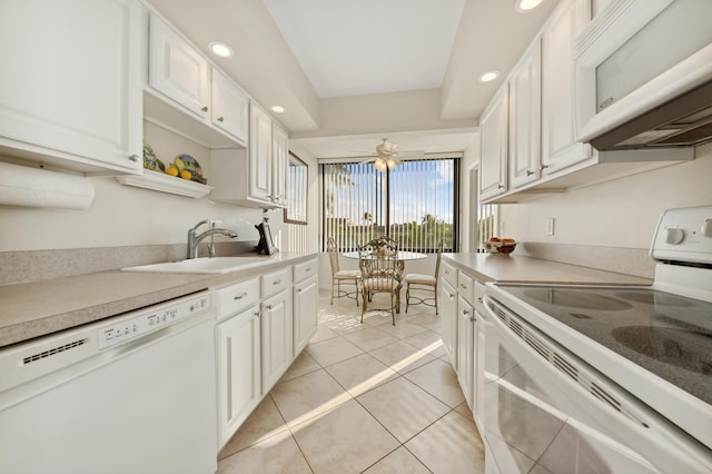 kitchen with light tile patterned flooring, white appliances, white cabinetry, and sink