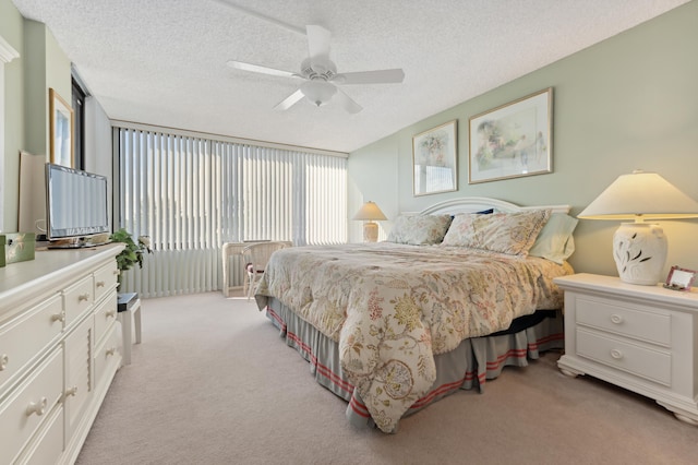 carpeted bedroom featuring a textured ceiling and ceiling fan