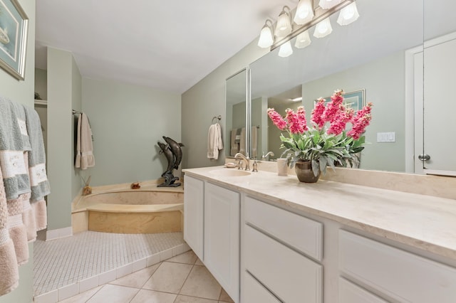 bathroom with tile patterned floors, a tub to relax in, and vanity