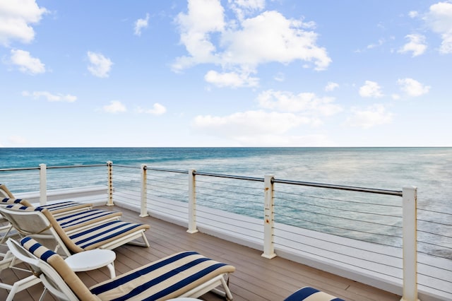 wooden deck featuring a view of the beach and a water view