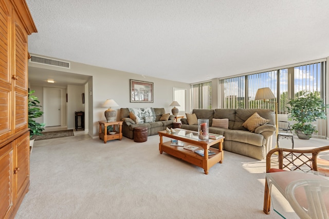 living room featuring light carpet, a textured ceiling, and a wall of windows