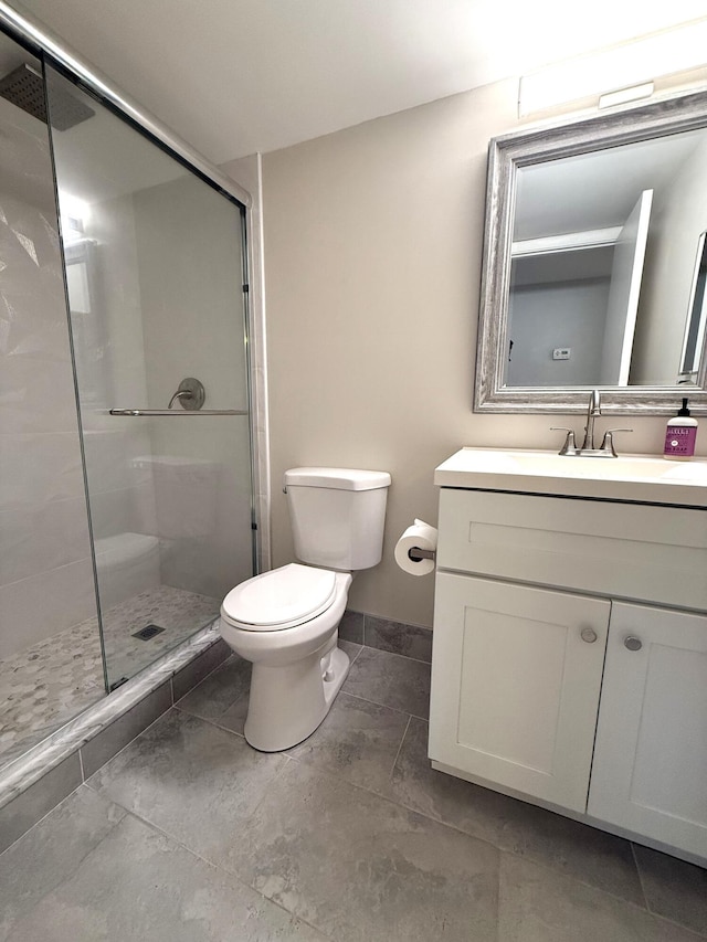 bathroom featuring vanity, an enclosed shower, and toilet