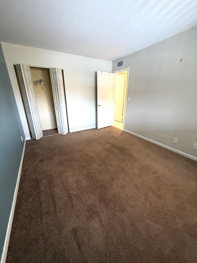 unfurnished room featuring dark carpet