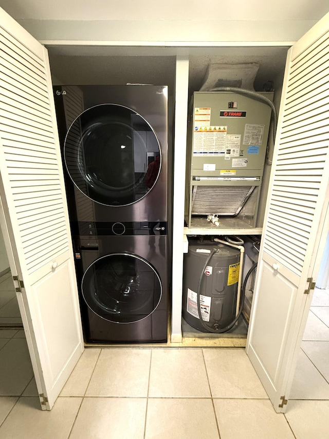 laundry room featuring stacked washer and dryer and light tile patterned floors