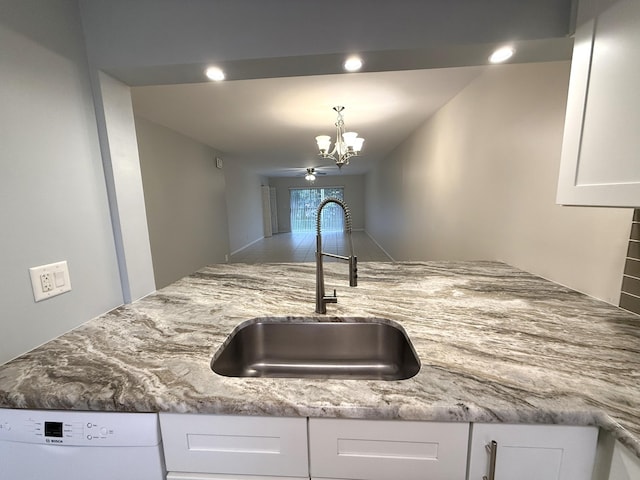 kitchen with dishwasher, sink, white cabinets, and light stone counters