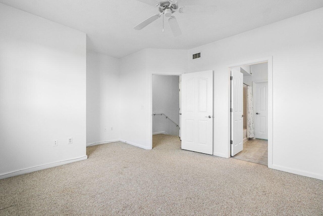 unfurnished bedroom with ensuite bath, light carpet, and ceiling fan