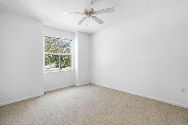 carpeted empty room featuring ceiling fan and a textured ceiling