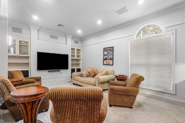 living room with built in features and ornamental molding