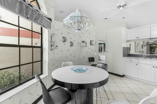 dining room featuring ceiling fan, light tile patterned floors, and vaulted ceiling