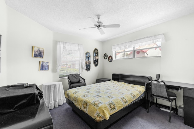 bedroom featuring dark colored carpet, ceiling fan, and a textured ceiling