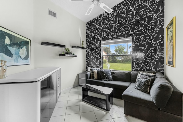 living room with light tile patterned floors, high vaulted ceiling, and ceiling fan