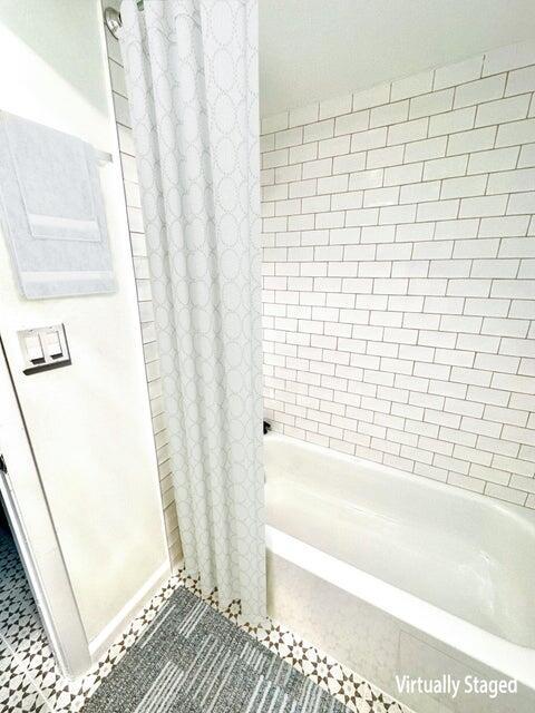 bathroom featuring shower / tub combo and tile patterned flooring