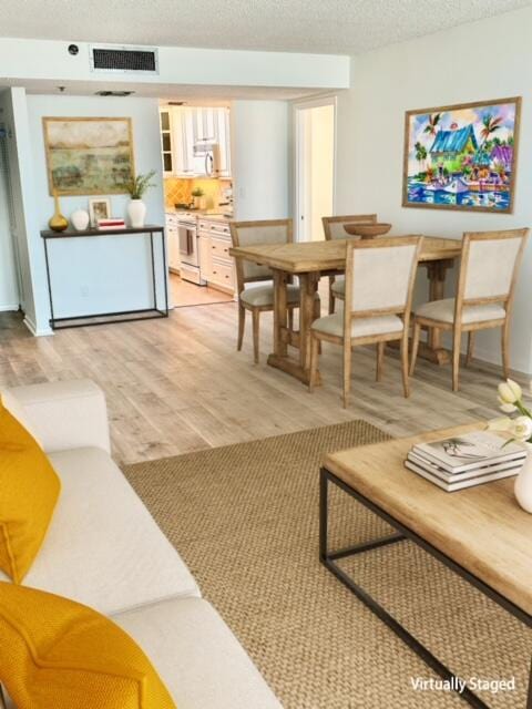 interior space featuring a textured ceiling and light hardwood / wood-style flooring