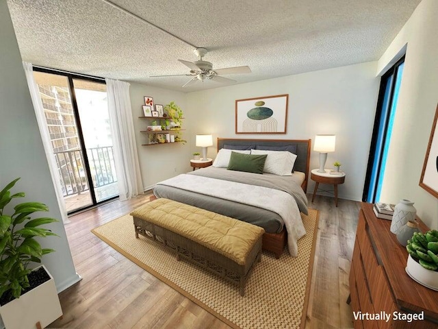 bedroom with a textured ceiling, ceiling fan, light hardwood / wood-style floors, and access to outside