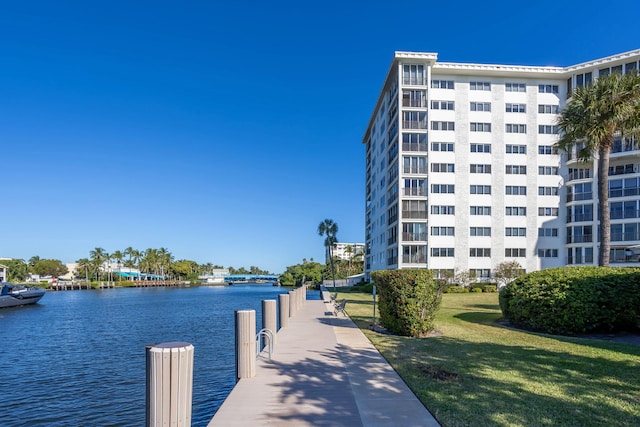 view of dock featuring a lawn and a water view