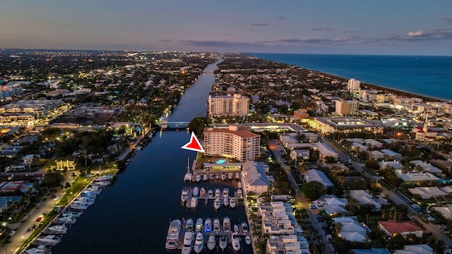 aerial view at dusk featuring a water view