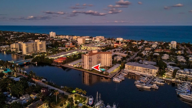 aerial view at dusk featuring a water view