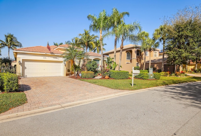 mediterranean / spanish home featuring a front yard and a garage