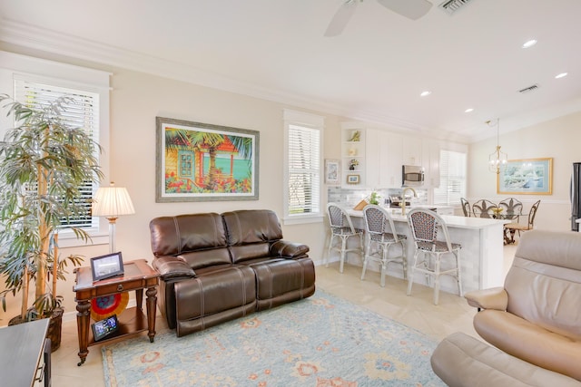 tiled living room with a wealth of natural light, crown molding, and ceiling fan with notable chandelier