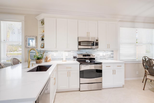 kitchen featuring white cabinetry, sink, tasteful backsplash, crown molding, and appliances with stainless steel finishes