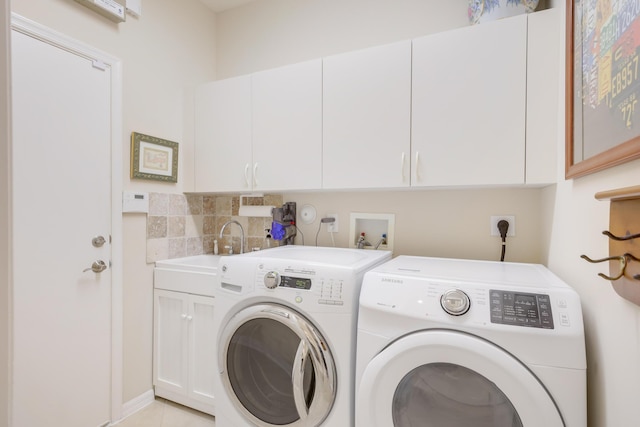 laundry room featuring cabinets, separate washer and dryer, and sink