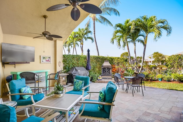 view of patio / terrace featuring an outdoor living space with a fireplace, ceiling fan, and area for grilling